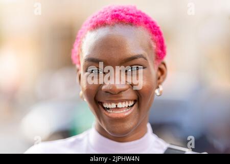 African woman with short pink hair smiling Stock Photo