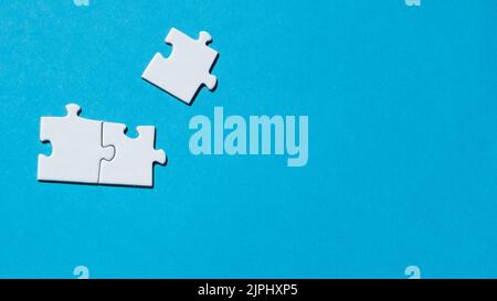 White puzzle pieces on the blue background. Concept of board game. Stock Photo