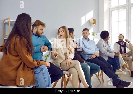 Team of entrepreneurs or corporate managers sitting in office and discussing something Stock Photo