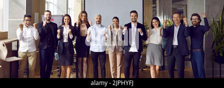 Satisfied business team clenched its fists in happiness rejoicing in its successful results. Stock Photo