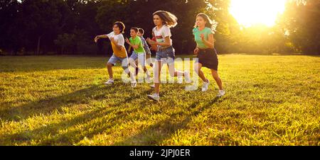 Group of happy little children enjoying summer, running in the park and having fun Stock Photo