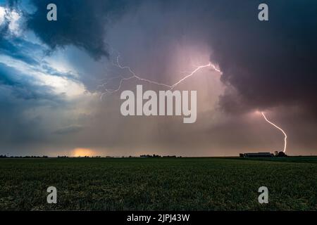 Wide angle view of lightning strike from a thunderstorm at sunset Stock Photo