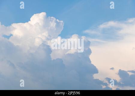 Fluffy clouds in blue sky - From below of fluffy white clouds floating over blue sky Stock Photo
