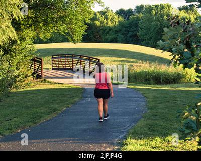 Olathe, Kansas - August, 18 2022 - Vibrant colors in this wide-angle shot of a walking trail bridge Stock Photo