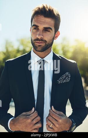 Dressed for success. a handsome young corporate businessman in a public park. Stock Photo