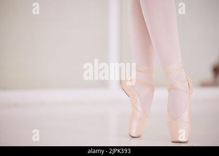 Ballet feet, legs or tiptoe of an elegant dancer dancing in a dance studio practicing for a performance. Closeup of a skilled and talented ballerina Stock Photo