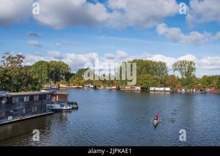 Crewing and Houseboats Amstel River in early Autumn, Amsterdam, Netherlands Stock Photo