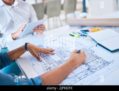 Architect sketching, designing blueprint or doing architecture, engineering or structure drawing on paper at a work studio with hands closeup Stock Photo