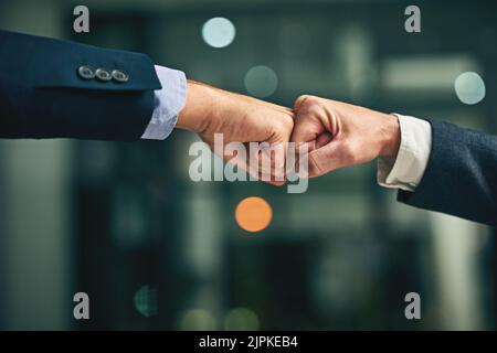 Ready to make it a team success. Closeup shot of two unidentifiable businessmen fist bumping in an office. Stock Photo