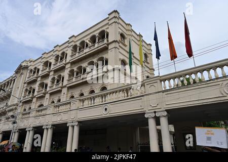 Kolkata, West Bengal, India - 21st July 2022 : Iconic Grand Hotel at Esplanade, Dharmatala area with waving flags and blue sky background. Stock Photo