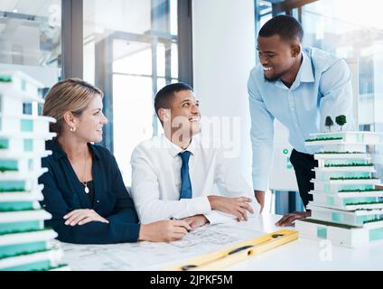 Architecture, interior and architect engineers with blueprint model and a floor plan planning together. Happy building designers working in Stock Photo