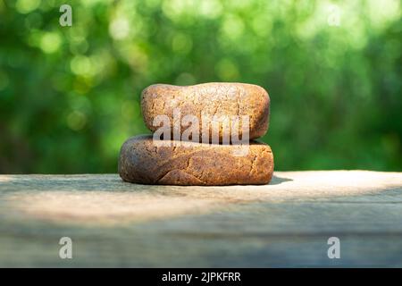 pieces of cannabis hashish with high thc closeup on nature green background. Stock Photo