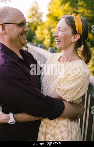 Husband and wife hug together and smile at each other Stock Photo