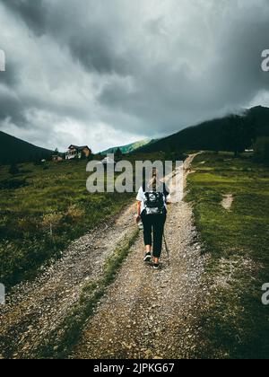 Young female tourism hiking in Carpathians mountains in foggy weather Stock Photo