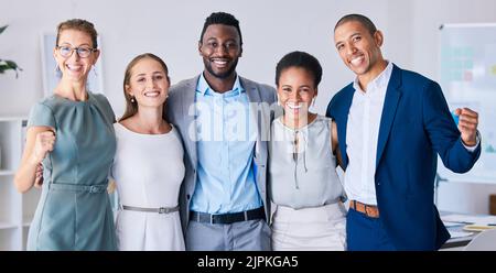 Multicultural, smiling and celebrating success, a startup group in a modern office. Attractive, diverse, young and happy team in the workplace, ready Stock Photo