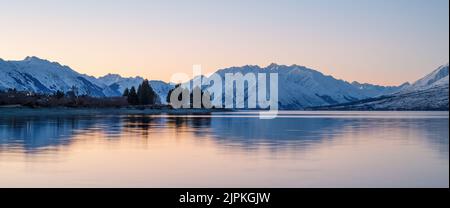 Snow-capped mountain range reflected in Lake Ohau at sunset, Twizel, South Island. Stock Photo