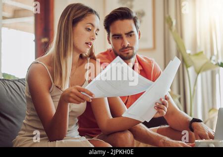 Budget, debt and mortgage with a couple reading bills and documents while checking their expenses and savings. Husband and wife looking worried while Stock Photo