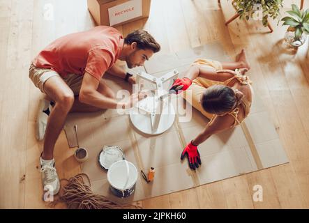 Couple fixing, DIY repair or painting a table, furniture or chair at home. Above creative husband and wife doing home improvement, decorating and Stock Photo