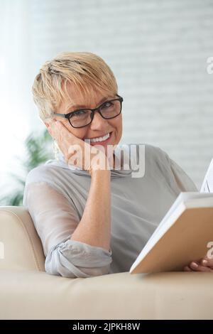 Pretty aged smiling woman with a book Stock Photo