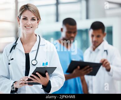 Science, innovation and health care with leading doctors working on digital tablet, planning together. Diverse healthcare professionals discussing Stock Photo