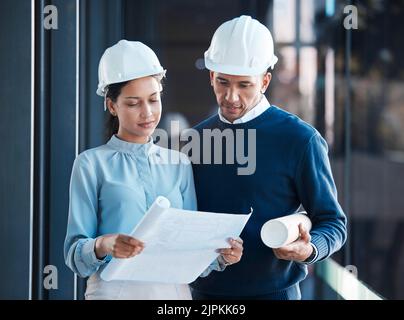 Architecture, civil and architect engineers busy with a floor plan or blueprint strategy on paper inside a office building. Designers working Stock Photo