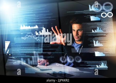 The information is there. Just reach out and grab it. a handsome young male computer programmer working on new code. Stock Photo