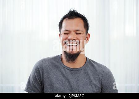 Portait of happy laughing bearded Filipino man Stock Photo