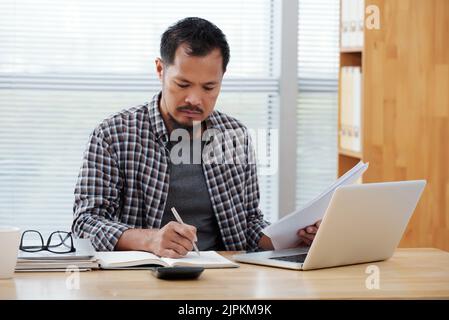 Businessman working with documents and taking notes Stock Photo