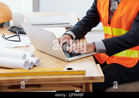 Cropped image of engineer working on laptop in his office Stock Photo
