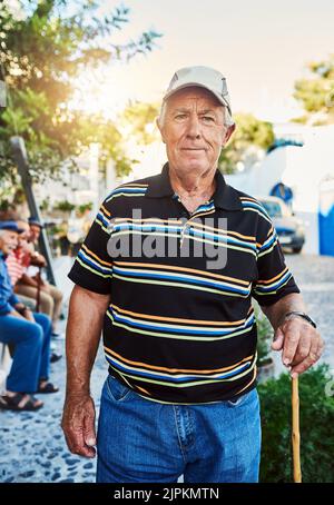 With age you become wiser. Portrait of a cheerful senior man wearing a hat and standing outside while looking at the camera. Stock Photo