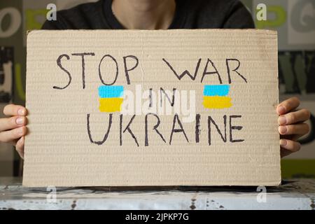 Stop the war in Ukraine written on a sign that a woman holds in her hands from her house in the Dnieper, protest action, martial law in Ukraine 2022 Stock Photo