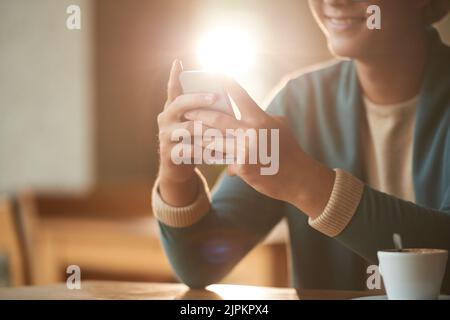 Smiling young man using application in his smartphone, backlit Stock Photo