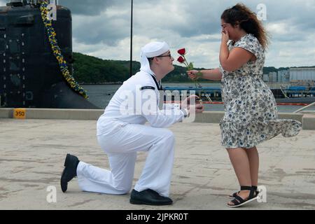 August 10, 2022 - Submarine Base New London, Connecticut, USA - Petty Officer 2nd Class Andrew Frable proposes to his girlfriend Nevada Currier during a homecoming event for the USS Indiana (SSN 789) at Naval Submarine Base New London in Groton, Conn., August. 10. Indiana returned to homeport from its 2nd full deployment since commissioning in support of the Navy's maritime strategy - supporting national security interests and maritime security operations - in the 6th Fleet area of operations. The Virginia-class fast attack submarine USS Indiana and crew operate under Submarine Squadron (SUBRO Stock Photo