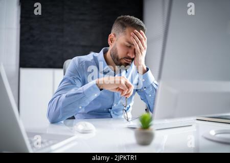 Stressed Sick Employee Man At Computer In Office Stock Photo