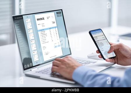 Young Businessman Looking At Invoice While Doing Online Banking On Phone Stock Photo