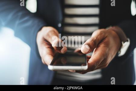Hands of business man typing on phone, networking on social media and browsing internet at work. Closeup of a professional corporate employee checking Stock Photo