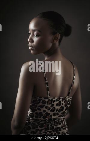 Young dark skin woman posing on front of dark background and looking to a point. High quality photo Stock Photo