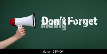 Female hand with megaphone and text DON'T FORGET on green background Stock Photo