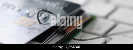 Fishing hook with credit cards and laptop on table, closeup. Cyber crime  Stock Photo - Alamy