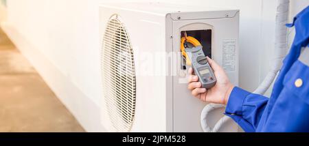Technician checking the operation of the air conditioner Stock Photo