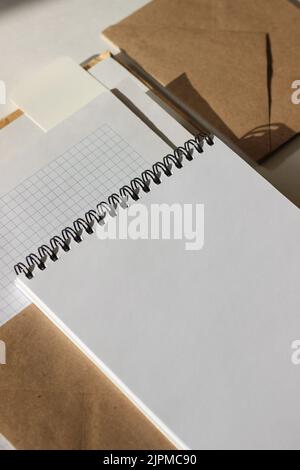 Blank Open Notebook, Paper Sheets, Envelopes on White Background. Minimal Mockup Template for Designer. Stock Photo