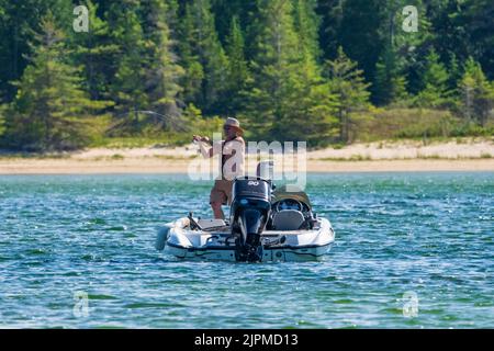 one of the draws to Washington island in Door county Wisconsin is the sport fishing. Here a lone fisherman try's his luck in Jackson Harbor. Stock Photo