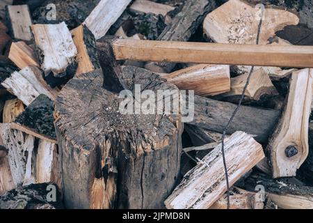 The ax lies on the wood. Firewood chopping. Preparation of firewood for the winter. Iron ax with wooden handle Stock Photo