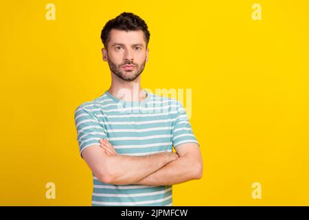 Portrait photo of young confident attractive man hands folded professional it programmer isolated on yellow color background Stock Photo