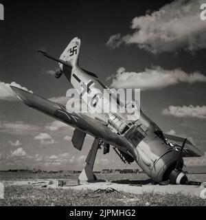 A German Focke-Wulf FW 190A-8 fighter abandoned on airfield at Steen Okkerzeel, north east of Brussels, Belgium, after it was liberated by British troops. A German single-seat, single-engine fighter aircraft designed in the late 1930s and started flying operationally over France in August 1941 and quickly proved superior in all but turn radius to the Spitfire Mk. V, the main front-line fighter of the Royal Air Force (RAF), particularly at low and medium altitudes.The 190 maintained superiority over Allied fighters until the introduction of the improved Spitfire Mk. IX. Stock Photo