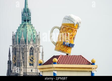 Munich Octoberfest, a large beer mug in Theresienwiese against the backdrop of St. Paul's Gothic church. Munich, GERMANY - August 2022 Stock Photo