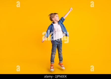 Full body portrait of carefree crazy person jump raise arm hold empty space isolated on yellow color background Stock Photo