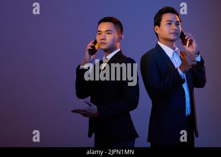 Portrait of business people talking on smartphone Stock Photo
