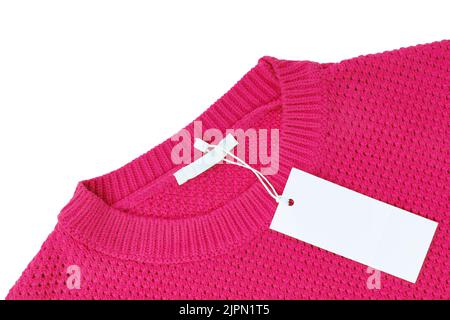 White blank rectangular clothing tag, label mockup template on pink knitted sweater isolated on white background . Price tag label with copy space for Stock Photo