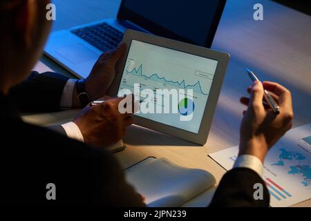 Businessman showing statistics on digital tablet to coworkers Stock Photo